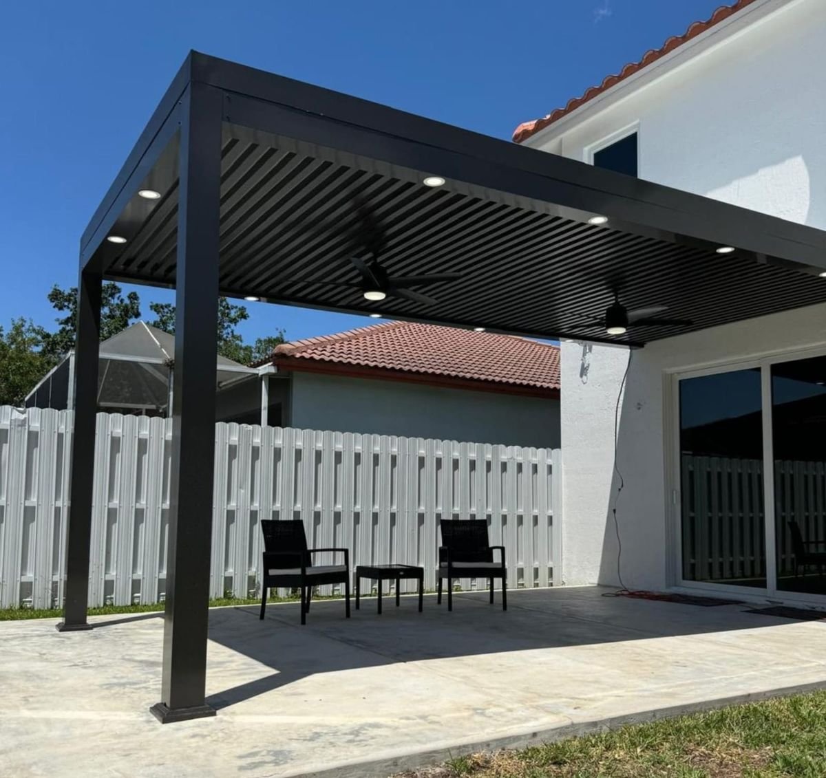 Black louvered aluminum pergola with LED lights and ceiling fan